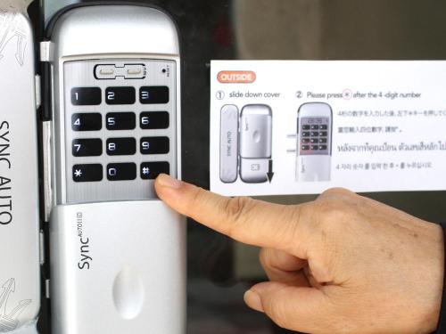 a hand pointing at a cell phone in a box at Tsukiji Hostel Wakayama 1 in Wakayama