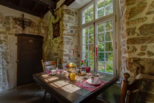 een houten tafel met eten erop in een kamer met een raam bij Chateau Le Val in Brix