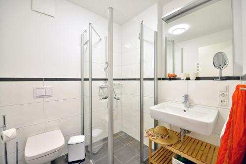 biała łazienka z umywalką i toaletą w obiekcie Ferienwohnung Strandküken w mieście Juliusruh