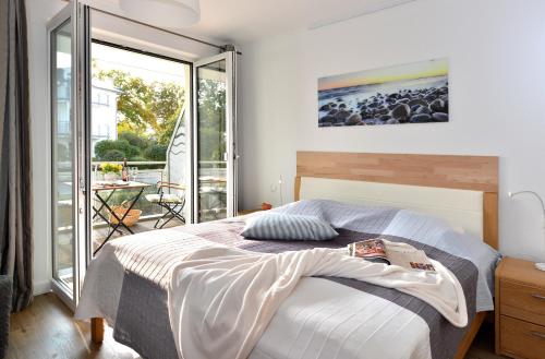 1 dormitorio con 1 cama y balcón en Ferienwohnung Strandküken, en Juliusruh
