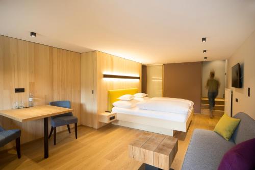 Habitación de hotel con cama, mesa y sillas en Landhaus Maria Grün B&B, en Feldkirch