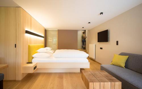 a bedroom with a white bed and a couch at Landhaus Maria Grün B&B in Feldkirch