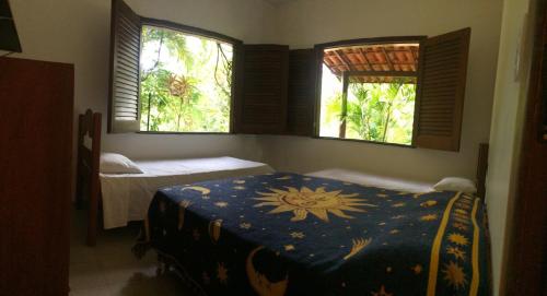 a bedroom with two beds and two windows at Casa Aldeia de Moreré in Moreré