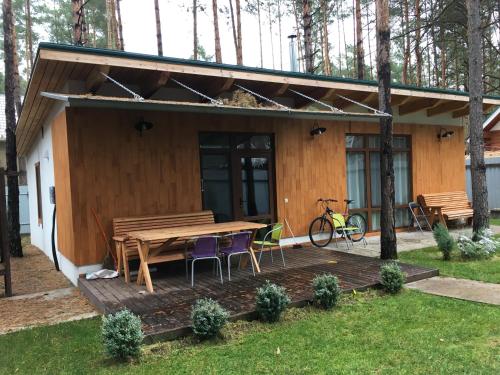 a house with a wooden deck with a table and chairs at Ekodom in Voropayev