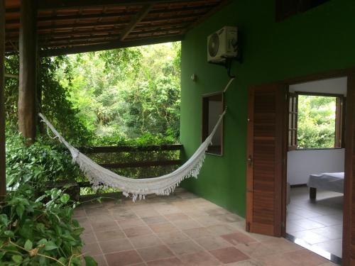 a hammock in a room with a green wall at Casa Aldeia de Moreré in Moreré