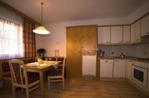 kuchnia z drewnianym stołem, stołem i krzesłami w obiekcie Alberts Bellevue Appartements w mieście Nauders