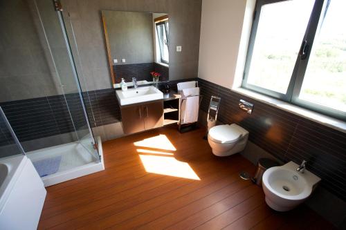 a bathroom with a toilet and a sink and a shower at Villa Mastlo in Assenta