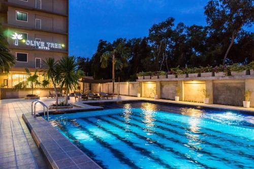 a pool at a hotel at night at Olive Tree Hotel Pattaya in Na Jomtien