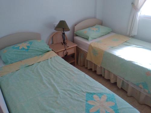 ロス・ニエトスにあるEl Palmeralのベッドルーム1室(ベッド2台、テーブルの上にランプ付)