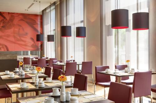 a dining room with tables and purple chairs at IntercityHotel Leipzig in Leipzig
