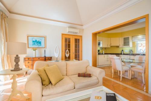a living room with a couch and a table at Luxury One Bedroom Palheiro Village by Holiday Rental Madeira in Funchal