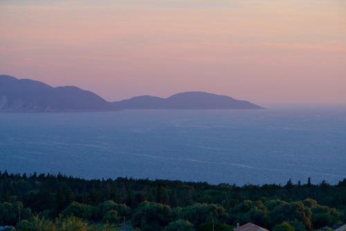 a view of the ocean with mountains in the distance at Euphoria Retreat in Mánganos