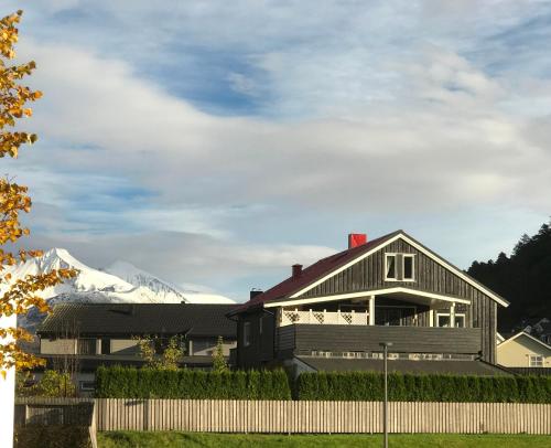 a house with a snow covered mountain in the background at Villa Åndalsnes in Åndalsnes