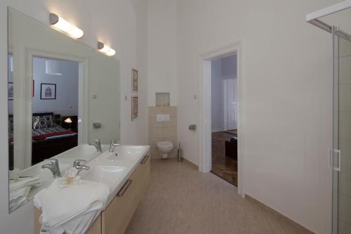 a white bathroom with a sink and a toilet at Victoria's Rooms 3 Bedrooms & 3 Baths, Free parking in Budapest