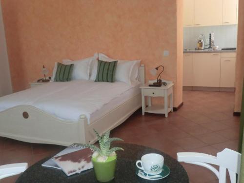 sypialnia z dużym białym łóżkiem i stołem w obiekcie Vecchia Osteria Seseglio w mieście Chiasso