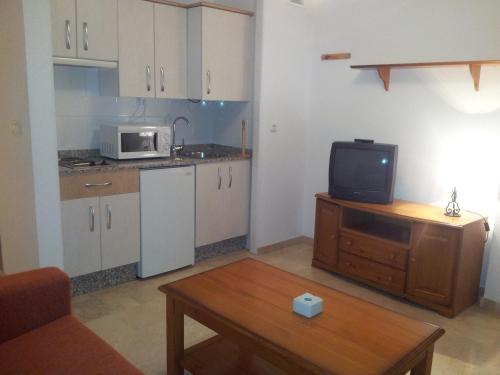 a small kitchen with a microwave and a table at Apartamentos Aixa in Caravaca de la Cruz