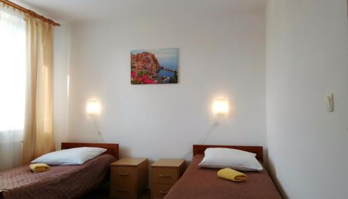 a bedroom with two beds and a picture on the wall at Hotel Eden in Rzeszów