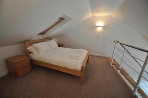 a small bedroom with a bed and a staircase at Princes Dock Chambers 10 in Hull