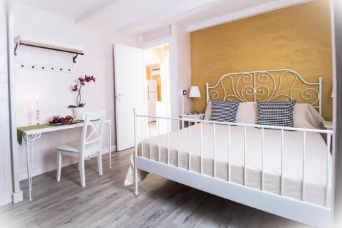 a white bedroom with a bed and a desk at cucaracha in Catania