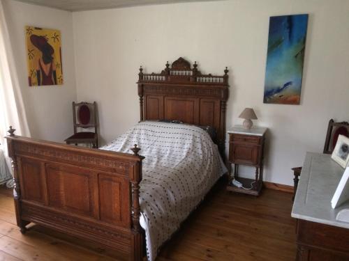a bedroom with a wooden bed with a wooden headboard at Lin-La-Bedin in Vielsalm