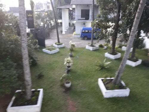 a view of a yard with trees and plants at The Kingston Hotel in Kiribathgoda