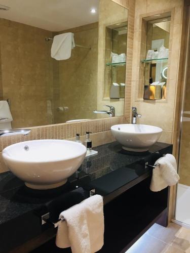 a bathroom with two sinks on a black counter at Burlington Hotel, BW Premier Collection by Best Western in Folkestone