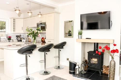 a kitchen with bar stools and a fireplace in a kitchen at Carlingford Sea Cottage in Carlingford