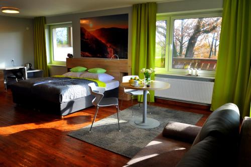 イェレニャ・グラにあるIdar Apartamentyのベッドルーム1室(ベッド1台、テーブル、ソファ付)