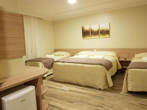 a room with three beds in a room at Sky Serra Hotel in Gramado