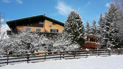 a house with a fence in the snow at Landhaus Santner - Örglwirt's Ferienwelt in Mariapfarr