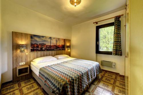 - une chambre avec un lit et une peinture murale dans l'établissement Italsol Residence Riai, à Moniga del Garda