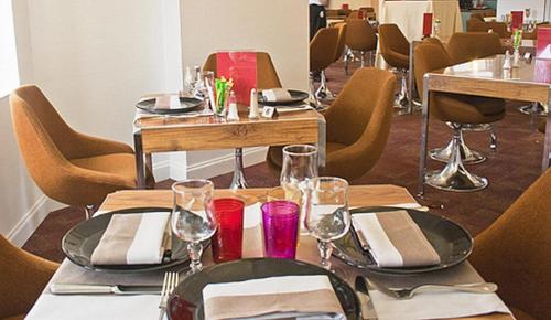 a table with plates and wine glasses on it at Logis Hôtel de France restaurant le Lucullus in Montmorillon