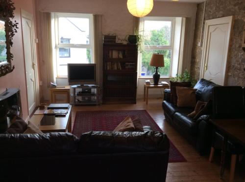 a living room with a couch and a tv at Comber Courtyard Apartment in Comber