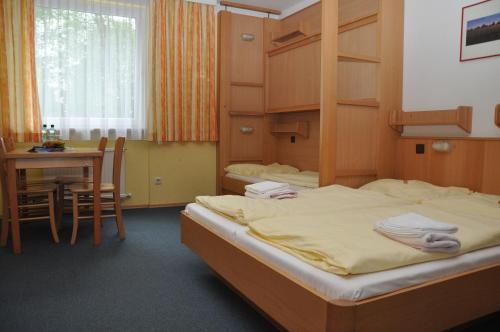 a bedroom with a bed and a table and a dining room at Eduard-Heinrich-Haus, Hostel in Salzburg