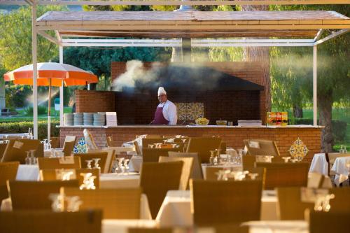 a chef standing behind the counter of a restaurant at MClub Lipari in Sciacca