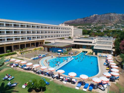 a hotel with a swimming pool with umbrellas and chairs at MClub Lipari in Sciacca