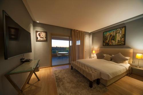 Un dormitorio con una cama, un escritorio y un televisor. en Villa Loubane, en Marrakech