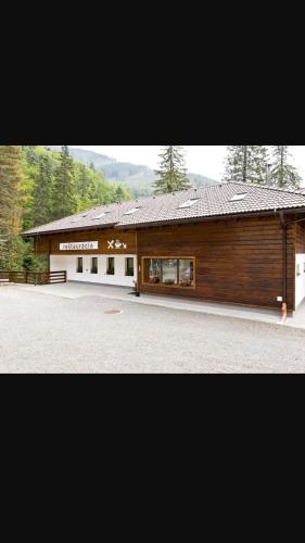a large wooden building in the middle of a road at Apartman Chopok Juh Ema Superior in Tale