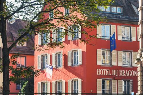 a red building with flags in front of it at Hôtel Du Dragon in Strasbourg