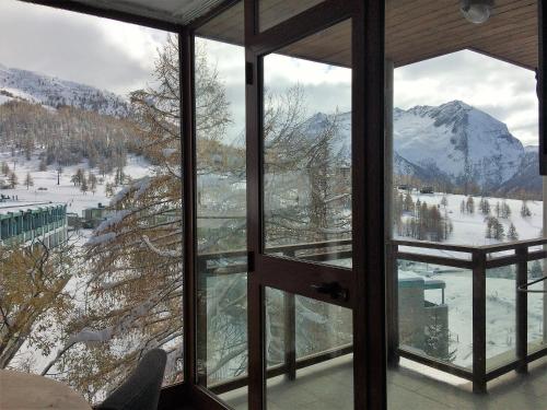a view of a snowy mountain from a room with windows at Shackleton Chalet in Sestriere