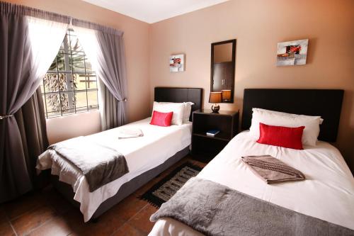 a bedroom with two beds and a window at Heaven Can Wait Countryside Estate in Riversdale