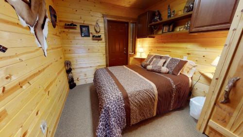 a bedroom with a bed in a log cabin at Long View Cabin, Breakfast Deck overlooking the Canyon! in Monticello