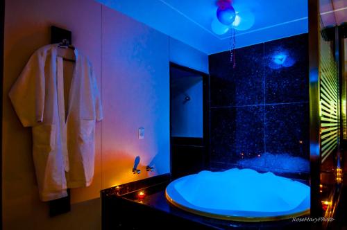 a bathroom with a shower with a blue light at Toulouse Motel (Adult Only) in Natal