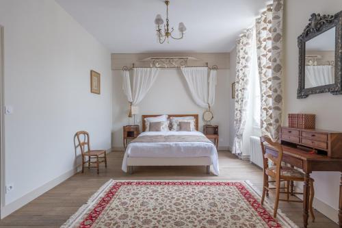 a bedroom with a bed and a desk and a mirror at La Perluette in Blois