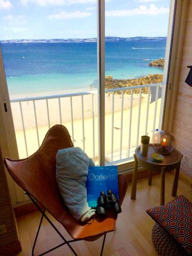 a room with a chair with a view of the beach at Glaz Ocean in Douarnenez