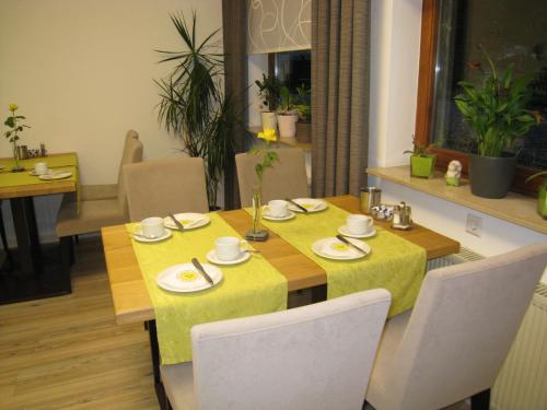 a dining room table with a yellow table cloth at Hotel Barbarina in Tübingen