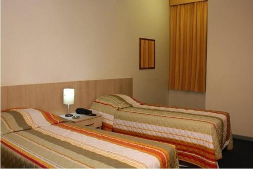 una habitación de hotel con 2 camas en una habitación en Euro Hotel, en Curitiba