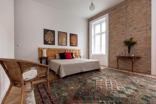 ブダペストにあるAnnie's 3 bed and 3 bathroom apartmentのベッドとレンガの壁がある寝室