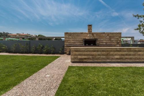 a backyard with a brick fireplace and grass at Maritina Apartments in Ixia