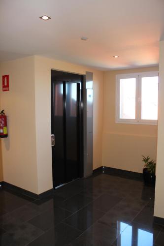 a room with a black door and a window at Ático Vista Alegre in Lerma